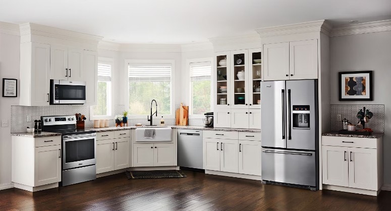 A modern kitchen showcases various appliances, highlighting the electrical demands of contemporary homes, with a visible circuit breaker panel that serves as a safety device to manage the electrical system and prevent overloads. The kitchen's design emphasizes efficiency and reliability in distributing power to the numerous devices in use.